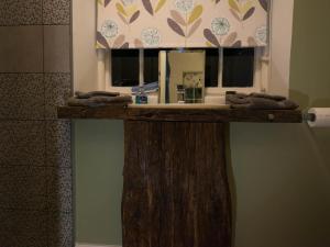 a bathroom counter with a sink and a mirror at Chapel House Cottage in Builth Wells