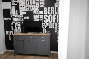 Habitación con escritorio, TV y pared cubierta de palabras. en Donizetti Residence, en Bérgamo