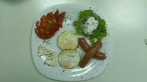um prato de comida com salsicha e legumes numa mesa em Luna apartman em Brcko