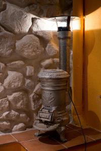 a lamp sitting next to a stone wall at Casa Rural Inma in Muñoveros
