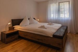 a bedroom with a bed with white sheets and a window at Chalet Gousweid- Mönch Apartment in Wilderswil