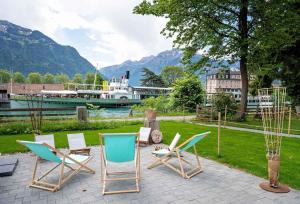 un grupo de sillas sentadas en un patio con un barco en RiverLodge TCS Training & Freizeit AG, en Interlaken