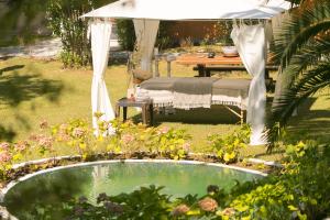 a small pool of water in a garden with a table at Mandraki Village Boutique Hotel in Koukounaries
