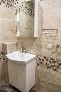 La salle de bains est pourvue d'un lavabo blanc et d'une douche. dans l'établissement Studio Vazrozhdenska, à Veliko Tarnovo