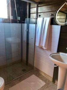 uma casa de banho com um chuveiro e um lavatório. em Pousada Arara Canindé em São Jorge