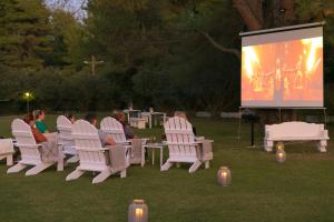 a group of people sitting in chairs in front of a screen at Mandraki Village Boutique Hotel in Koukounaries