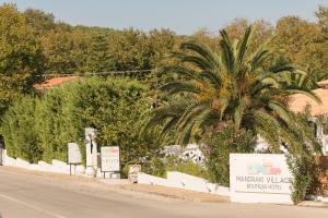 a palm tree on the side of a road at Mandraki Village Boutique Hotel in Koukounaries