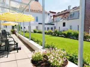 un patio con tavoli e ombrelloni in un cortile di Hotel Gollner a Graz