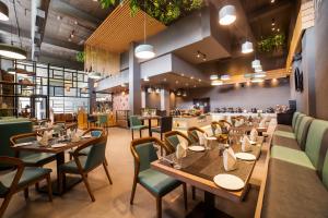 a restaurant with wooden tables and green chairs at The Fern Residency Bhopal in Bhopal