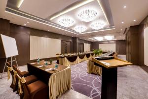 a conference room with tables and chairs and chandeliers at The Fern Residency Bhopal in Bhopal