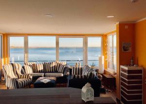 a living room with couches and a view of the ocean at Hausboot Elandi in Bitterfeld