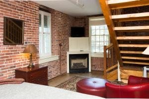 a brick room with a bed and a fireplace at The Common Man Inn & Restaurant in Claremont