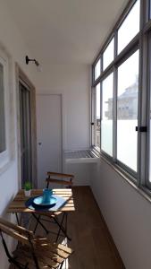 a room with a table and chairs and windows at Apartamento Blue dream in Sesimbra