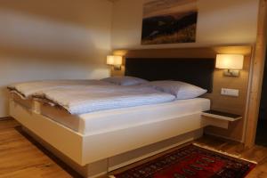 a bed in a room with two lights on the wall at Schwarzwaldhuus Feldberg in Feldberg