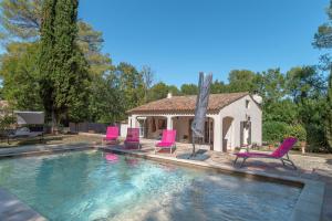 Una piscina con sillas rosas y una casa. en Villa les Pins, en Callas 24 fotos más