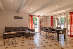 una sala de estar con un sofá, una mesa y sillas en Villa les Pins, en Callas