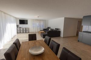 uma sala de estar com uma mesa de madeira e cadeiras em Chalet Gousweid- Harder Apartment em Wilderswil