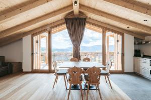 uma sala de jantar com mesa e cadeiras e uma grande janela em Lochbauer em Meltina