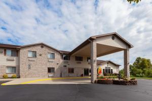 a large brick building with a large garage at Super 8 by Wyndham Big Rapids in Big Rapids