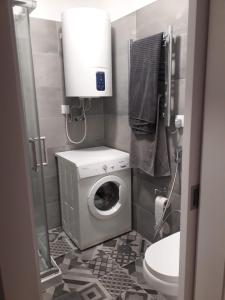 a bathroom with a washing machine and a toilet at Apartamento Blue dream in Sesimbra