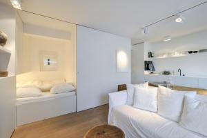 a white room with a couch and a bed at Julias Stay in Knokke-Heist