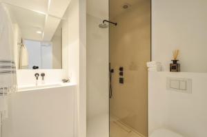 a white bathroom with a shower and a sink at Julias Stay in Knokke-Heist