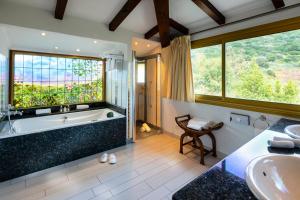 a bathroom with a tub and a sink at Hotel Le Maquis in Porticcio
