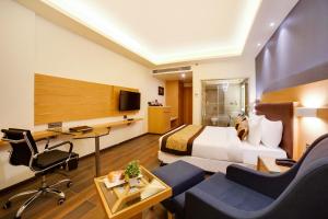 a hotel room with a bed and a desk at The Fern Residency Bhopal in Bhopal