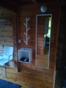 a room with a wall with a mirror and a chair at Isotalo Farm at enäjärvi lake in Salo