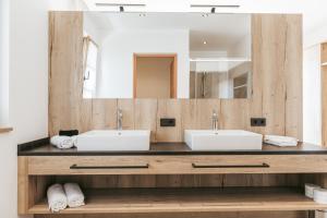 a bathroom with two sinks and a large mirror at Lochbauer in Meltina