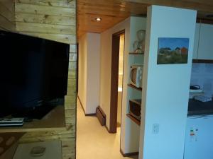a living room with a large television and a living room with a unintention at Colorina Las Leñas - Consorcio ATENAS in Las Lenas