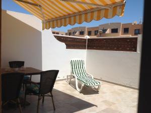 a patio with a table and chairs and a boat at Sonder in Caleta De Fuste