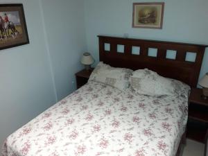 1 dormitorio con 1 cama con colcha de flores en Colorina Las Leñas - Consorcio ATENAS en Las Lenas