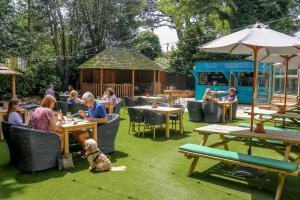 a group of people sitting at a restaurant with a dog at The Canford in Poole