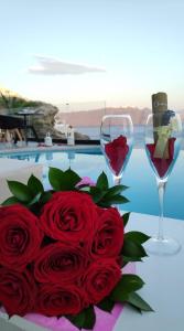 a bouquet of red roses and a glass of wine at Santorini Secret Suites & Spa, Small Luxury Hotels of the World in Oia
