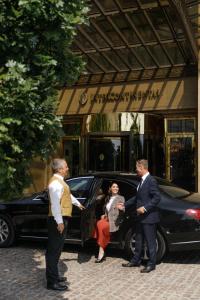 un grupo de personas parados fuera de un coche en InterContinental - Kyiv, an IHG Hotel, en Kiev