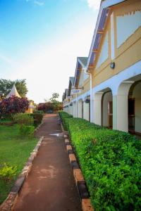 a walkway next to a building next to a yard at Hotel Premier in Yumbe