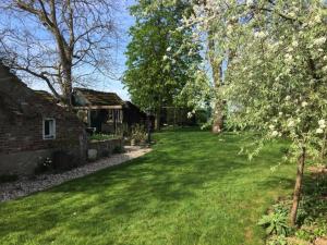 une cour d'une ancienne maison en pierre avec des arbres et de l'herbe dans l'établissement Halte Bontebrug, à Silvolde