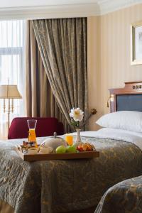 InterContinental - Kyiv, an IHG Hotel في كييف: علبة فاكهة على سرير في غرفة الفندق