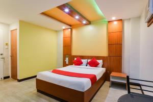 una camera da letto con un grande letto con cuscini rossi di OYO 473 Ranchotel Drive-in a Biñan