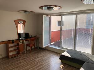 a bedroom with a bed and a desk and a window at Penzión Dukát in Prešov