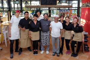 a group of people posing for a picture in a restaurant at Camping Village Mar y Sierra in San Costanzo