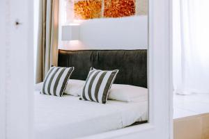 a mirror reflecting a bed with two pillows on it at Dimora Anderì in Polignano a Mare