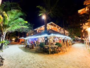 a restaurant with tables and chairs on the beach at night at Cocoloco Beach Resort in Boracay