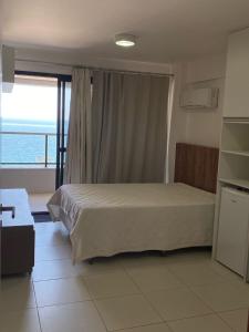 1 dormitorio con cama y vistas al océano en Apartamento Ondina Choice, en Salvador