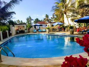 a large swimming pool in a resort with palm trees at Blue Bay Cove, Penthouse 4 in Watamu
