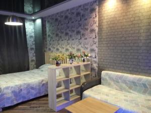 a bedroom with a bed and a table and a couch at Apartment on Yuvilejnyj avenue in Kharkiv