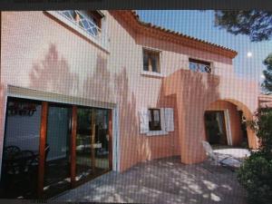 a pink building with a chair in front of it at Maison D architecte chez Huguette in Villalier