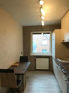 eine Küche mit einem Tisch und einem großen Fenster in der Unterkunft 3 -Zimmer Wohnung im Zentrum Bad Nenndorf in Bad Nenndorf