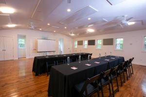 a conference room with tables and chairs and a screen at Dahlonega Resort and Vineyard in Dahlonega
